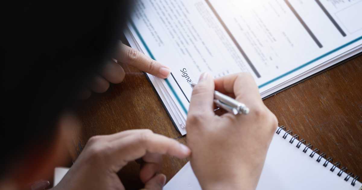 A customer signing a loan refinance agreement